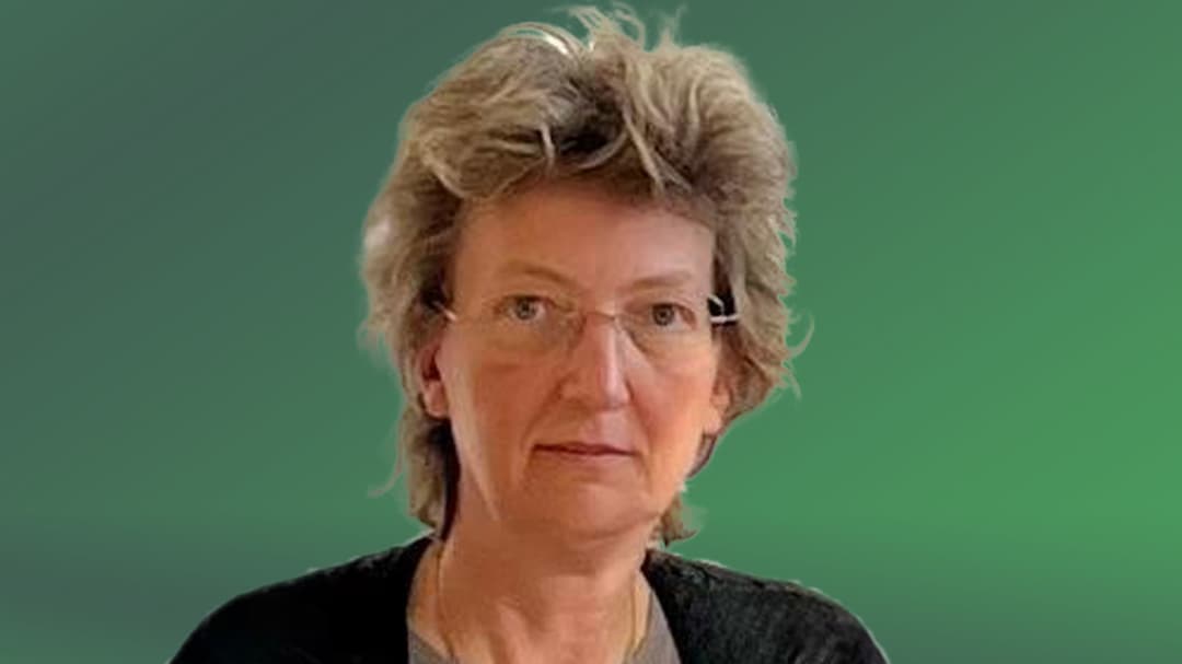  A portrait of a woman, against a green background.