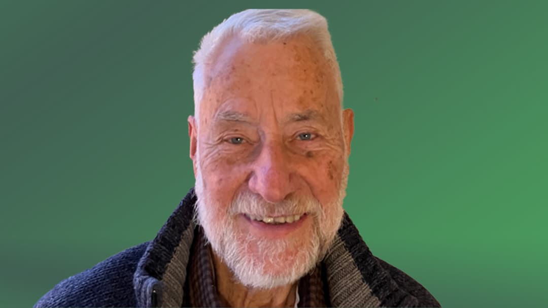  A man smiles and looks into the camera.