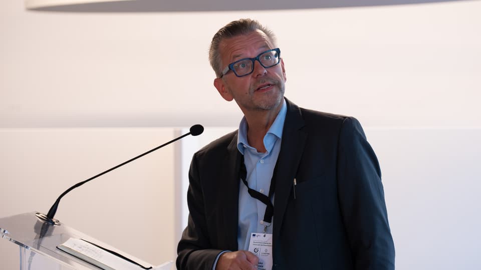 A man speaks into a small microphone.