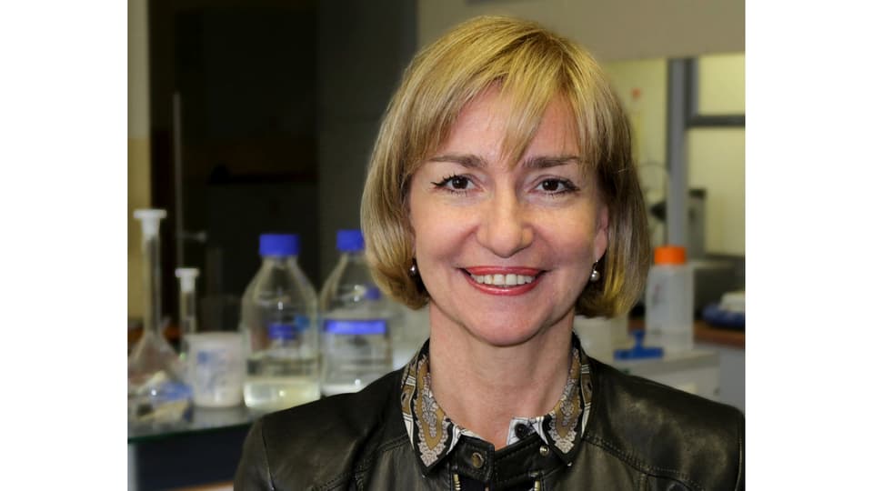 A woman with blond hair, dressed in a shirt and jacket.